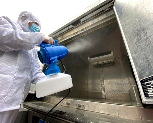 作业人员使用专用电动喷雾机对货车货箱内部进行喷雾消毒