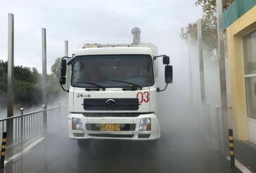 冷链园区门口全自动360度车辆消毒装备工作中,货车通过雾化消毒通道