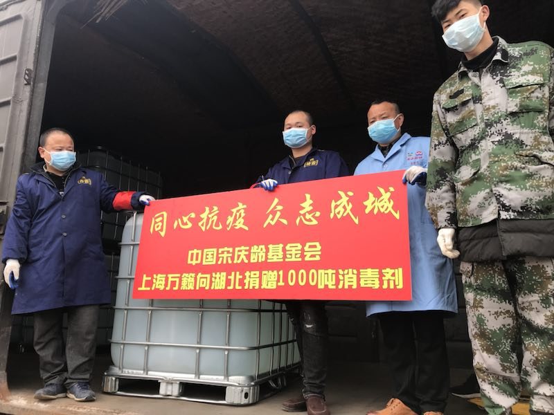 2020年抗疫物资发运现场，工作人员在货车车厢前展开同心抗疫众志成城横幅