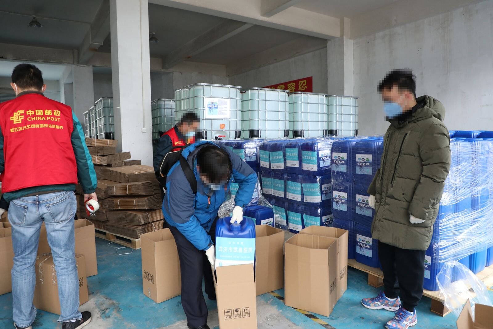 志愿者和工作人员在仓库将CELA消毒剂逐桶分装打包发往武汉(人脸已做模糊处理)